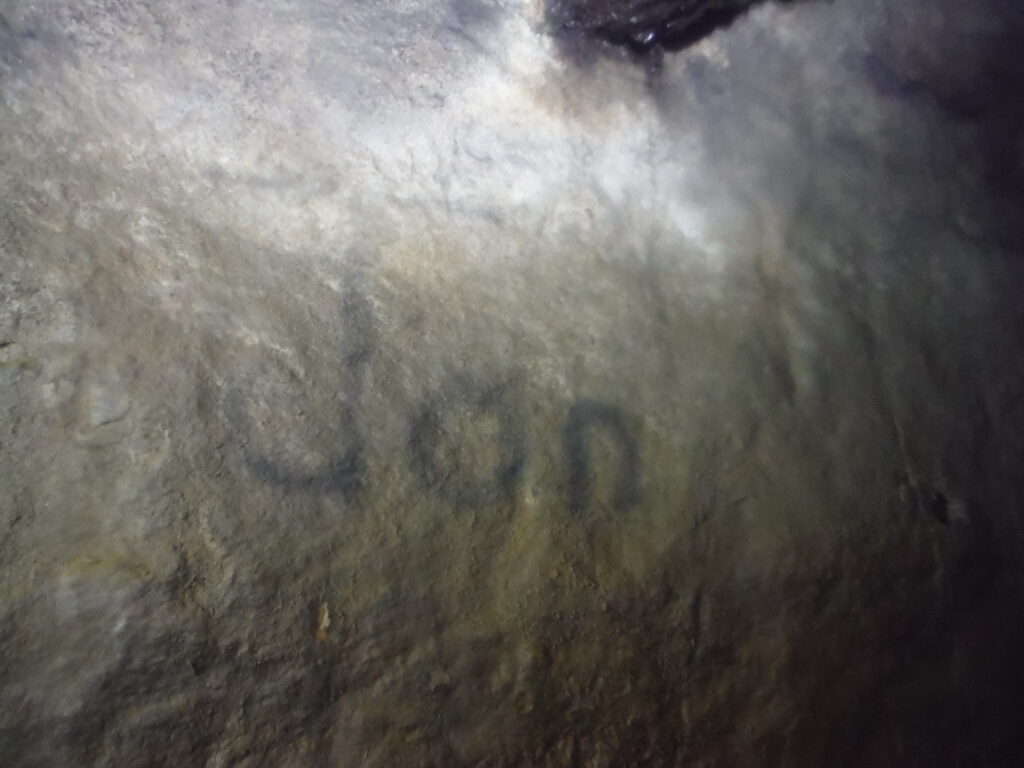 The word Jan inscribed on the wall, possibly with a carbide lamp. 